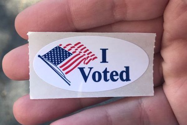 I voted sticker held in a voter's hand